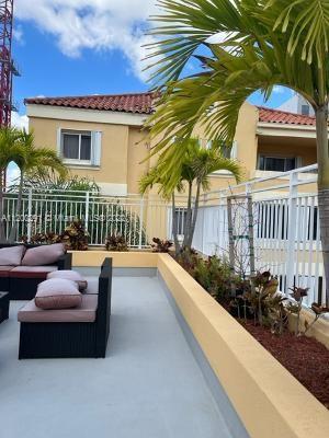 Outdoor view of a two-story house with a tiled roof and patio seating.