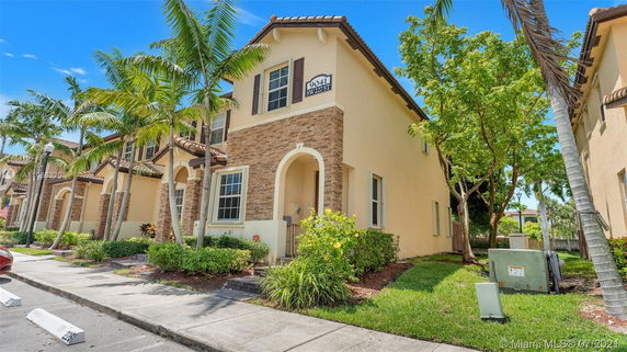 Front view of a two-story house with stone accents and archway entrance.