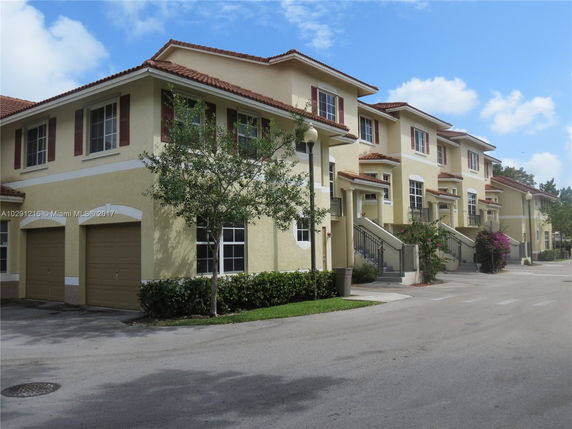 Front view of a multi-story townhouse with garages.