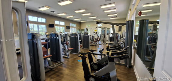 Indoor gym area with various fitness equipment and large windows.