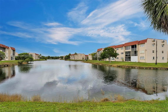 Buildings with red roofs overlooking a calm body of water.