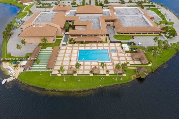 Aerial view of a large complex with a central swimming pool near a body of water.