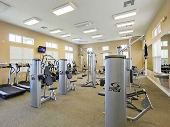 Indoor gym area with various exercise equipment and machines.