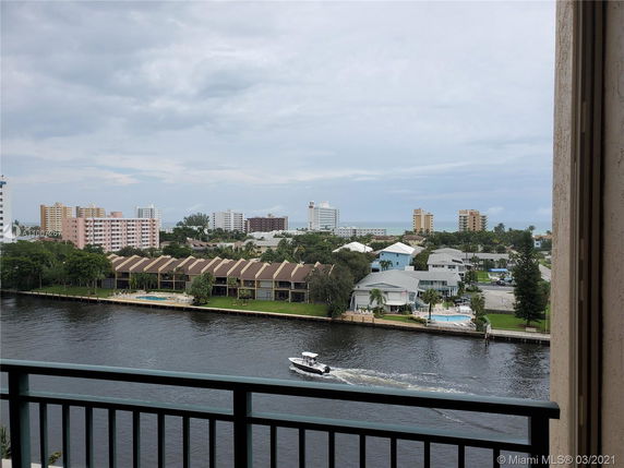 View from a balcony overlooking a river with buildings in the background.