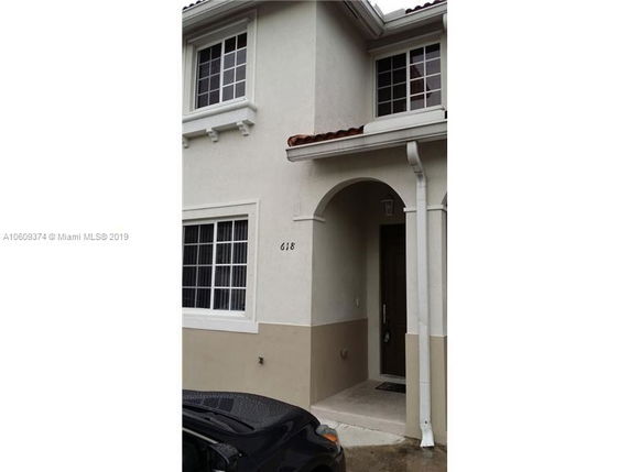 Front view of a two-story house with an arched entrance.
