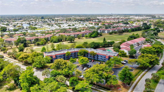 Aerial view of a residential area with multiple buildings surrounded by trees.