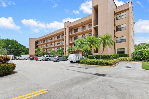 View of a multi-story building with adjacent parking area.