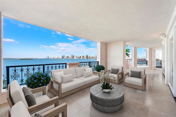 Covered outdoor seating area with a beautiful view of a coastline and city skyline.