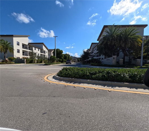Front view of modern multi-story buildings with surrounding trees and vegetation.