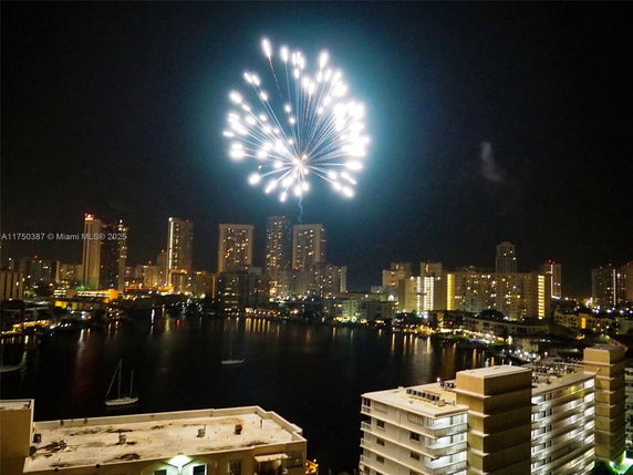 Nighttime panorama of a cityscape with fireworks lighting up the sky.