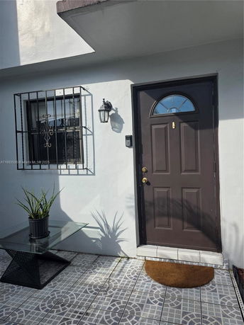 Front view of a house with a dark front door and barred window.