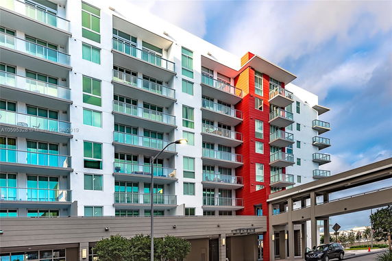 Front view of a multi-story apartment building with balconies.