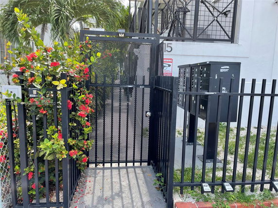 Front view of a building entrance with a metal gate and mailbox area.