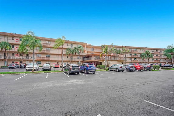 Outdoor parking area in front of a multi-story residential building.