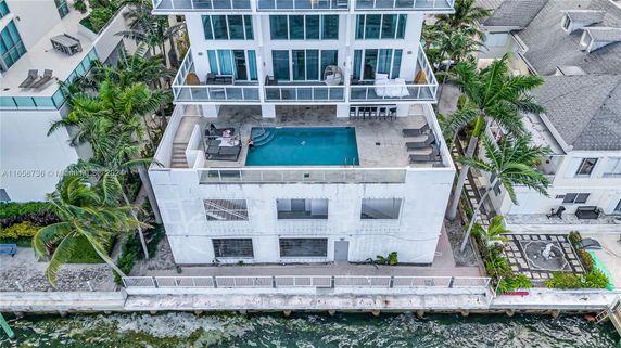 Rooftop view of a modern multi-story building featuring a swimming pool and seating area.