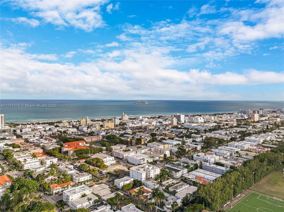 Wide view of a coastal cityscape with buildings and ocean in the background.