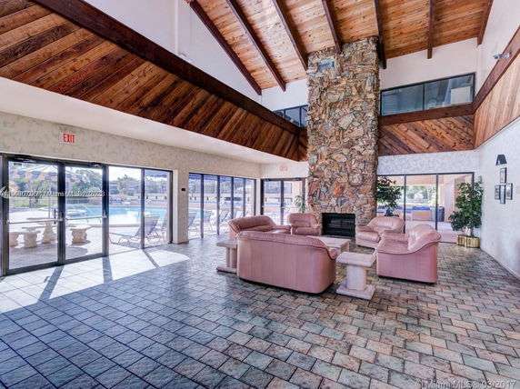 Interior view of a clubhouse with a stone fireplace and leather seating.