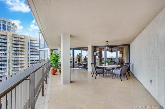 Wide balcony view with seating area, showing various high-rise buildings in the background.