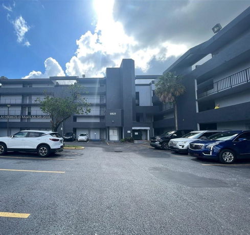 Outdoor parking area in front of a multi-story building.