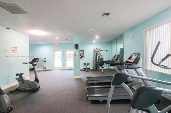 Interior view of a gym with exercise equipment including treadmills and exercise bikes.