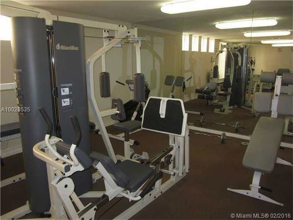Indoor gym area with exercise equipment and mirrors.