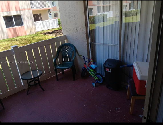 Outdoor patio area with a table, chairs, and a child's bicycle.