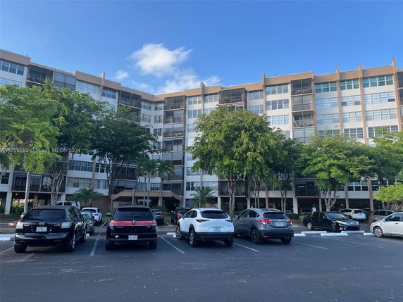 Front view of a multi-story building with parking area.