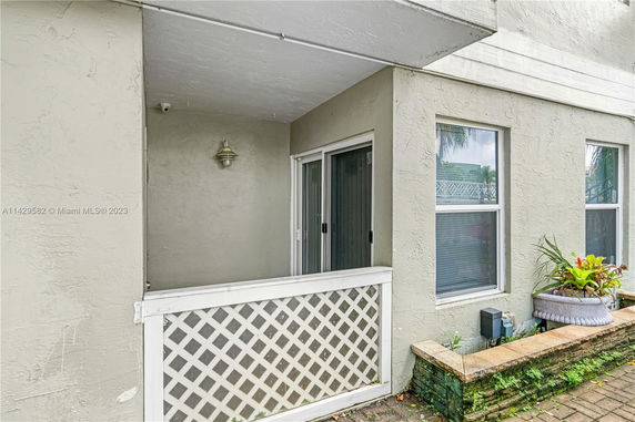 Front view of a building with a small patio area and sliding glass door.