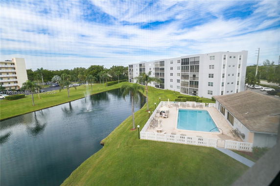 View of multi-story buildings with a swimming pool and a pond.