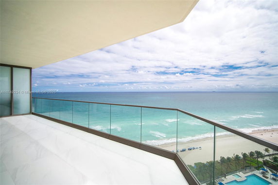 Panoramic view from a balcony overlooking the ocean and beach.