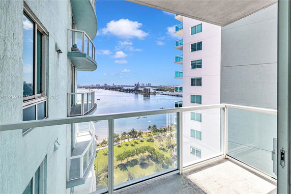 View from a building balcony overlooking a river with cityscape in the background.
