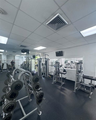 Room with gym equipment including weights and exercise machines.