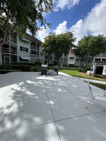 View of an outdoor area with a multi-story residential building in the background.
