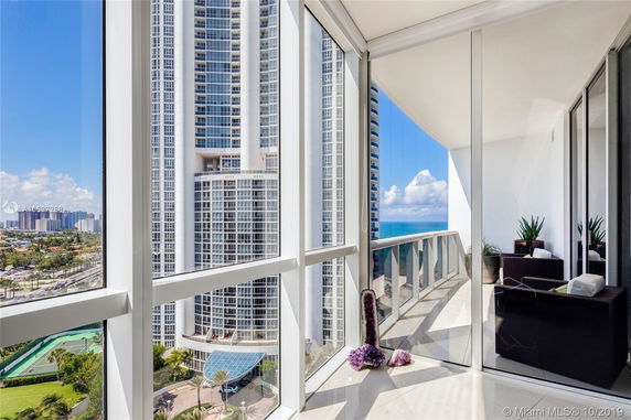 View from a balcony showing surrounding high-rise buildings and the sea.