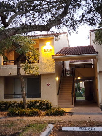 Front view of a building with an external staircase and a tiled roof.