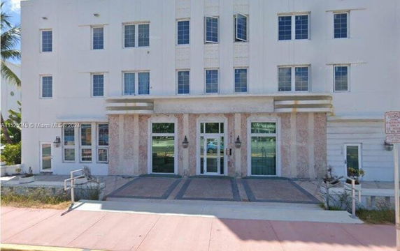Front view of a multi-story building with several windows and entrance doors.
