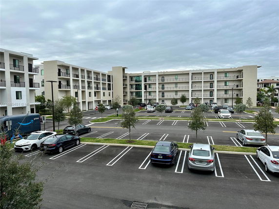 Outdoor parking area in front of a four-story residential building.