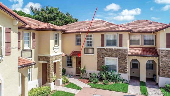 Front view of a two-story townhouse with a red-tiled roof and stone accents.