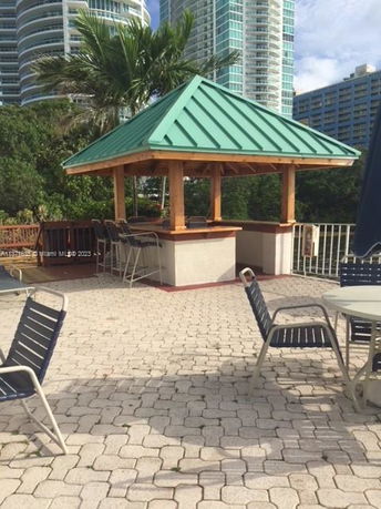 Rooftop area with a small pavilion featuring a green metal roof and seating arrangements.