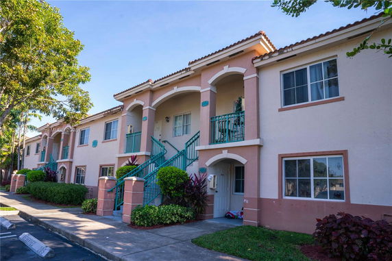 Front view of a two-story residential building with stairs and balcony.
