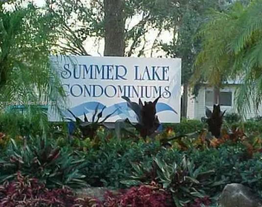 Sign of Summer Lake Condominiums surrounded by plants.