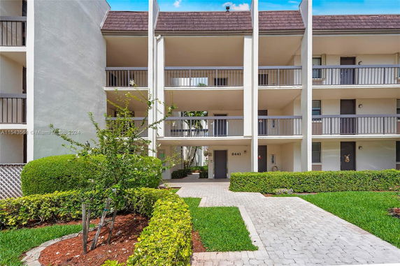 Front view of a multi-story apartment building with balconies.
