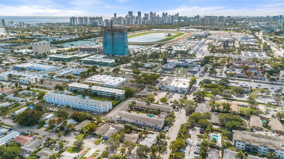 Aerial view of an urban area with residential and commercial buildings, and a large racetrack.