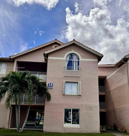 Front view of a multi-story residential building with balconies.