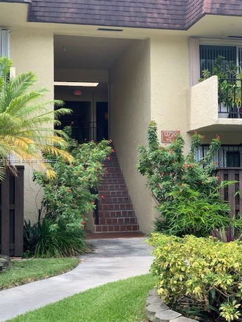 Entrance view of a multi-story building with stairs leading up.