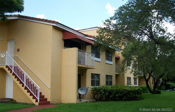 Front view of a two-story building with external staircase and balconies.