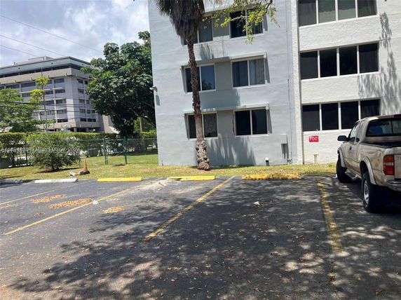 Outdoor parking area beside a multi-story building.