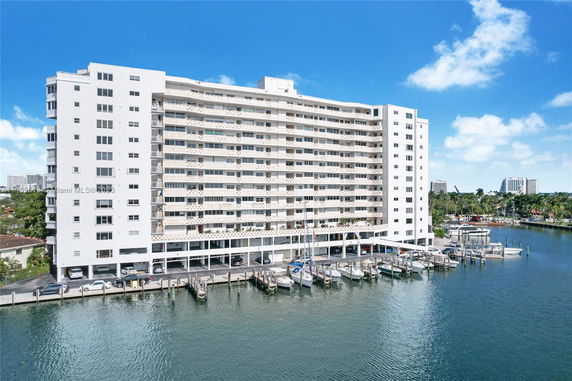 Front view of a multi-story building with balconies by the water.