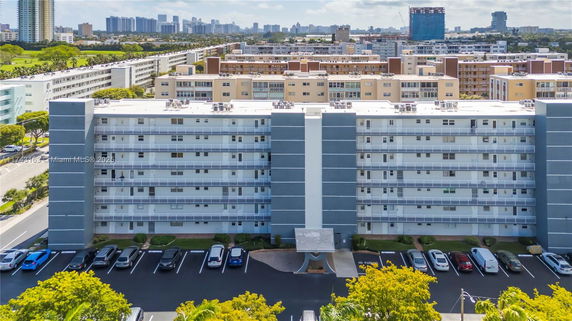 Front view of a multi-story residential building with balconies and parking area.