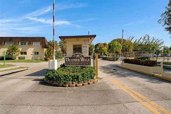 Front view of a condominium complex with a security gate and signage.